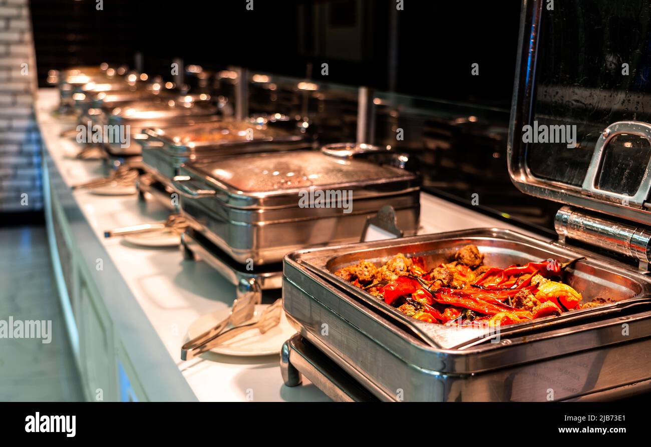 Colazione e pranzo buffet cibo catering banchetti in hotel. Contenitore buffet riscaldato con carne e pepe Foto Stock