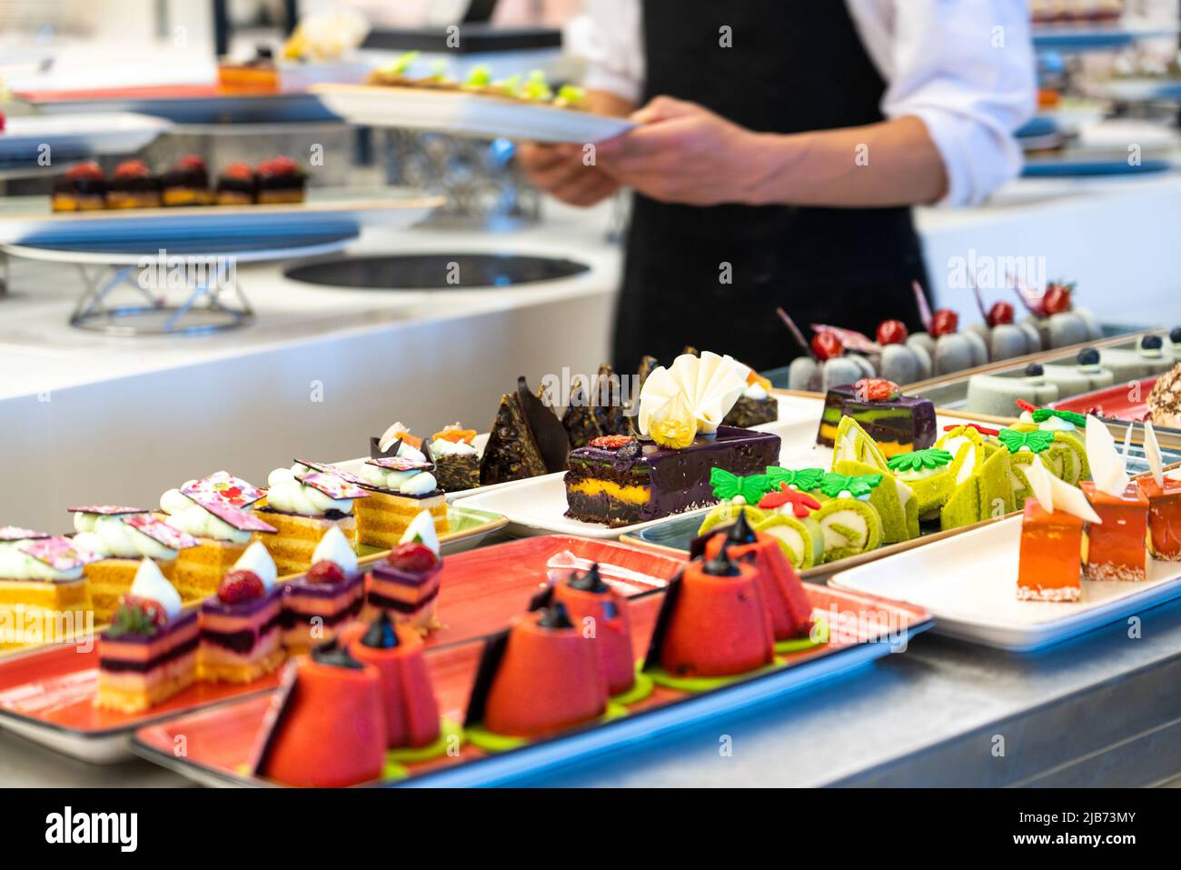 Il cameriere porta dolci e torte al bar dell'hotel Foto Stock