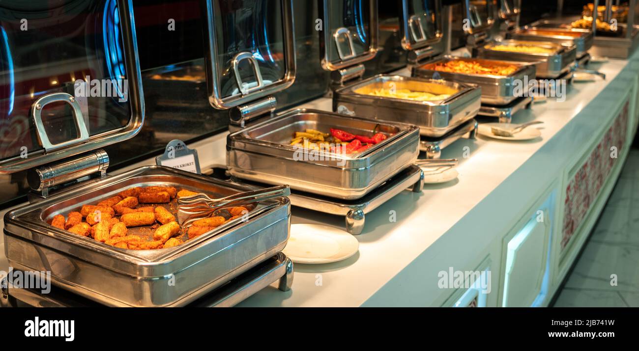 Contenitori riscaldati a buffet con patate a bastoncini per la colazione nel ristorante dell'hotel Foto Stock