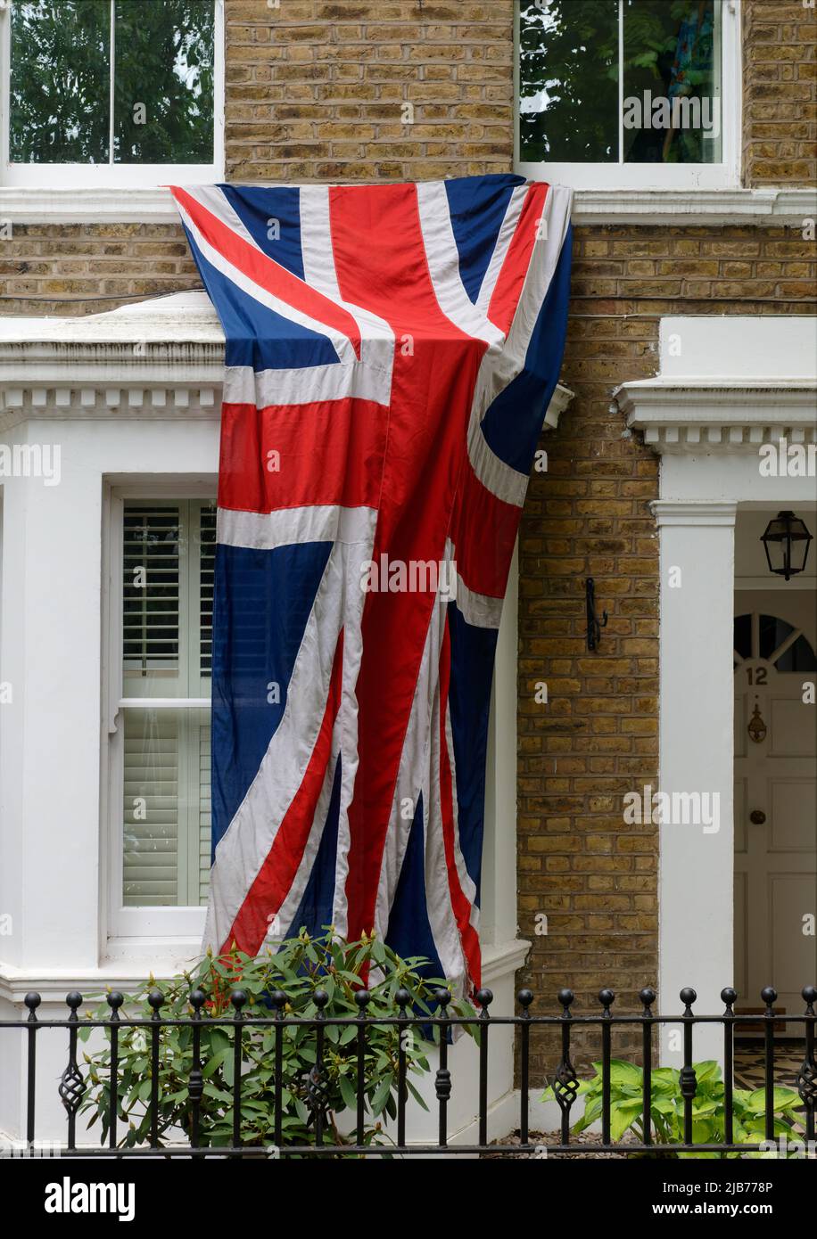 Grande Union jack bandiera britannica drappeggiato dalle finestre per le celebrazioni del Giubileo del platino della regina Elisabetta. Foto Stock