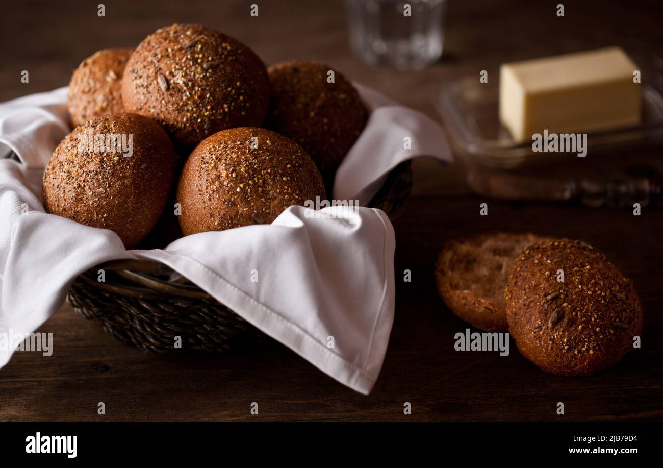 Un cestino di panini da pranzo appena sfornati con burro Foto Stock