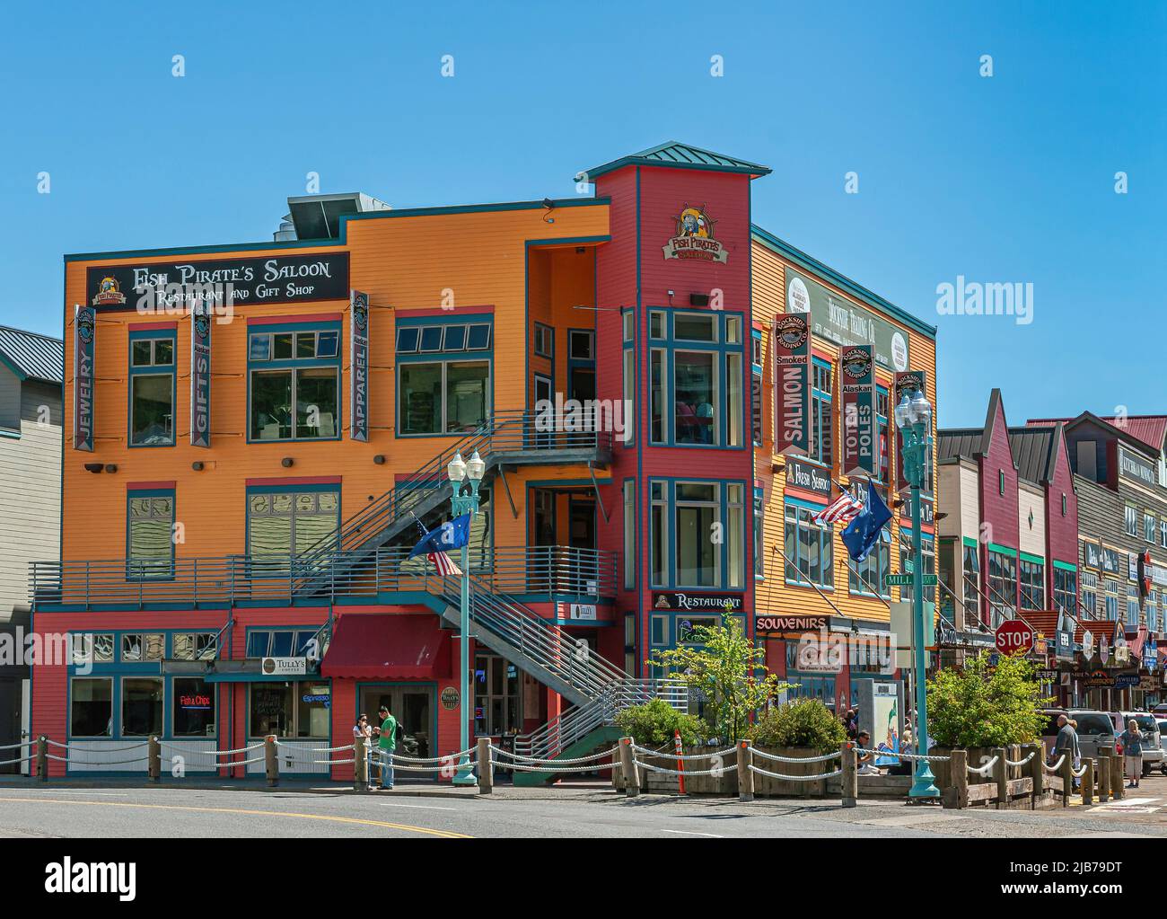 Ketchikan, Alaska, Stati Uniti d'America - 17 luglio 2011: Pesce Pirate's Saloon colorato business building sul fronte e Mill Street angolo sotto il cielo blu. Più negozi e. Foto Stock