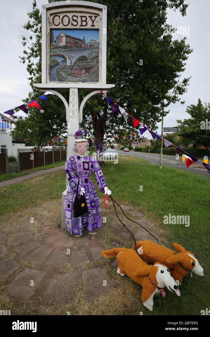 REGNO UNITO. 03rd giugno 2022. COSBY, LEICESTERSHIRE, INGHILTERRA. GIUGNO 3RD 2022. Una versione accovacciata della Regina Elisabetta II e del Royal Corgis sono visibili accanto al cartello d'ingresso del villaggio durante le celebrazioni del Giubileo del platino della Regina Elisabetta II a Cosby, Leicester. Credit: james holyoak/Alamy Live News Foto Stock