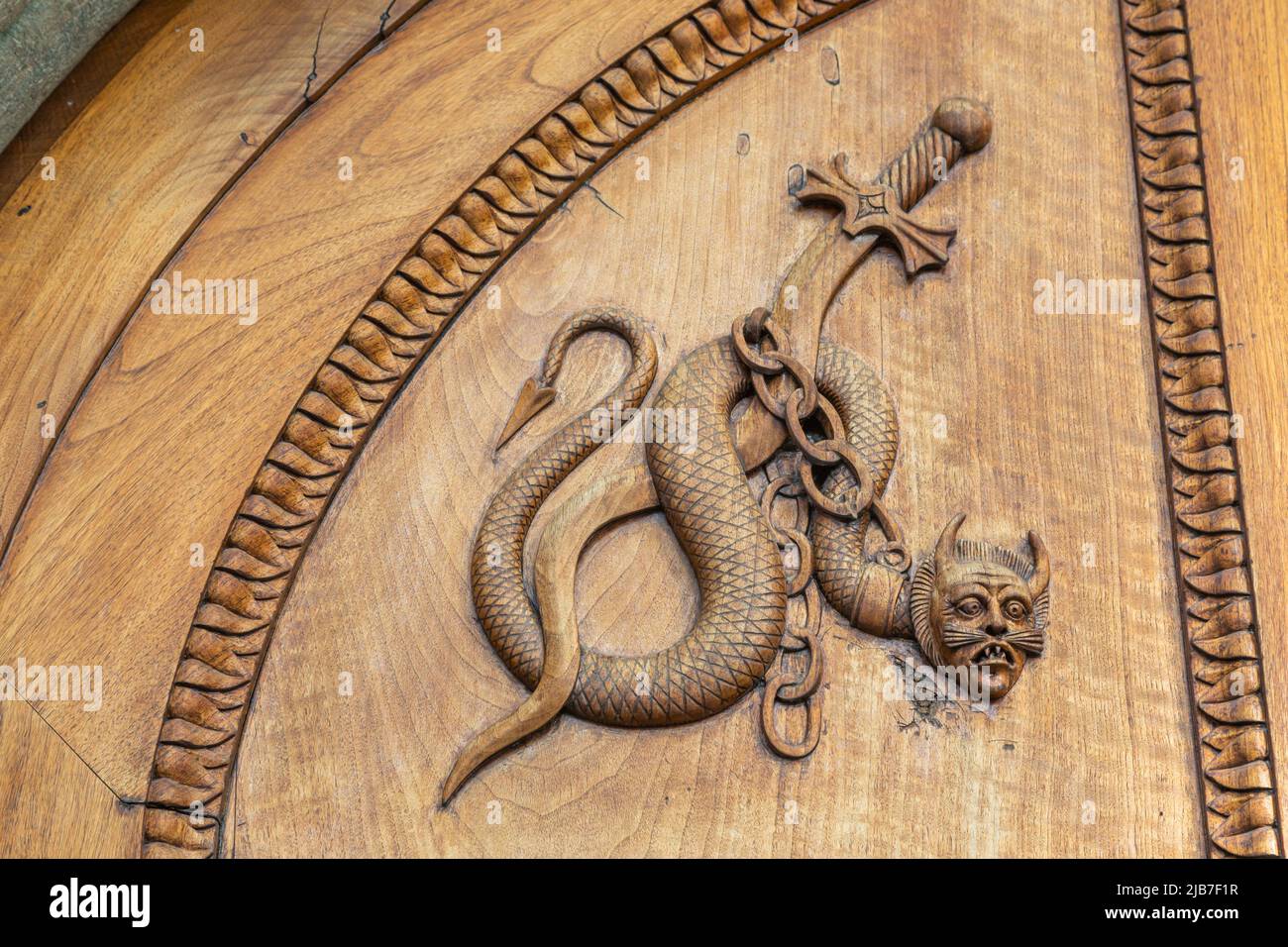 Serpente diavolo simbolo. Fantasia creatura magica su una vecchia porta, 12th secolo Abbazia, Italia. Foto Stock