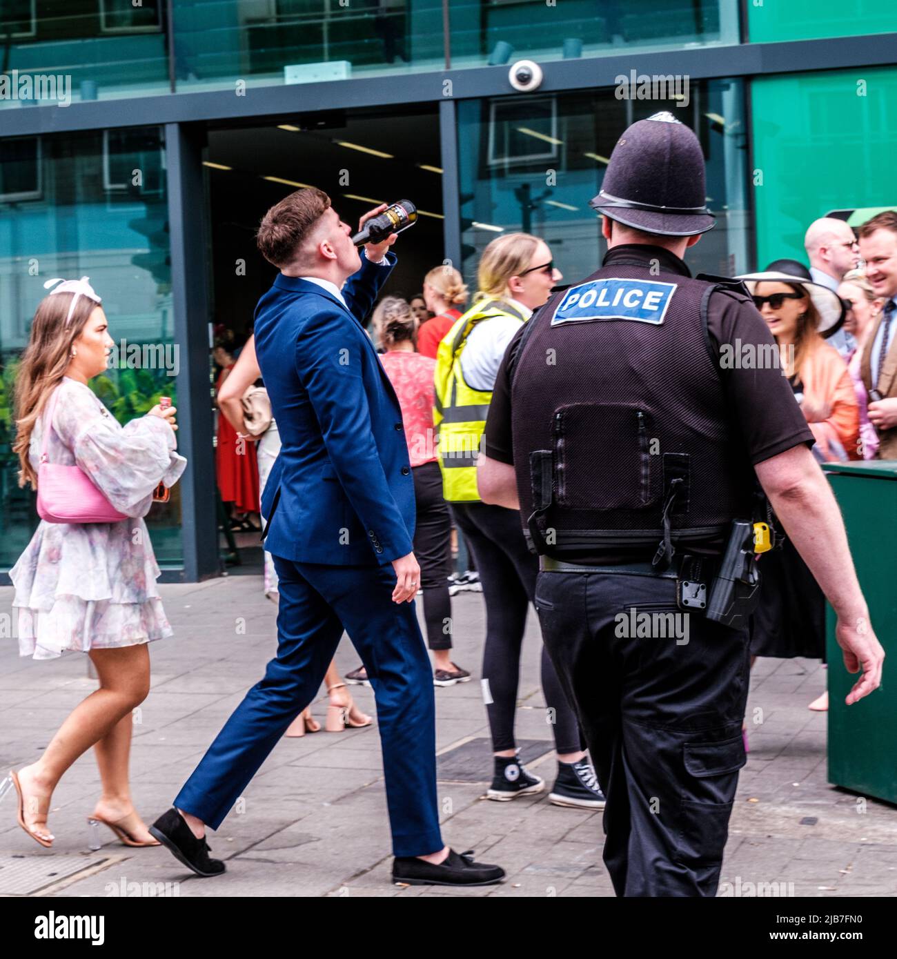 Epson Surrey, Londra UK, giugno 03 2022, ufficiale di polizia che guarda l'uomo giovane bere alcol sulla strada fuori dalla stazione ferroviaria di Epsom Foto Stock