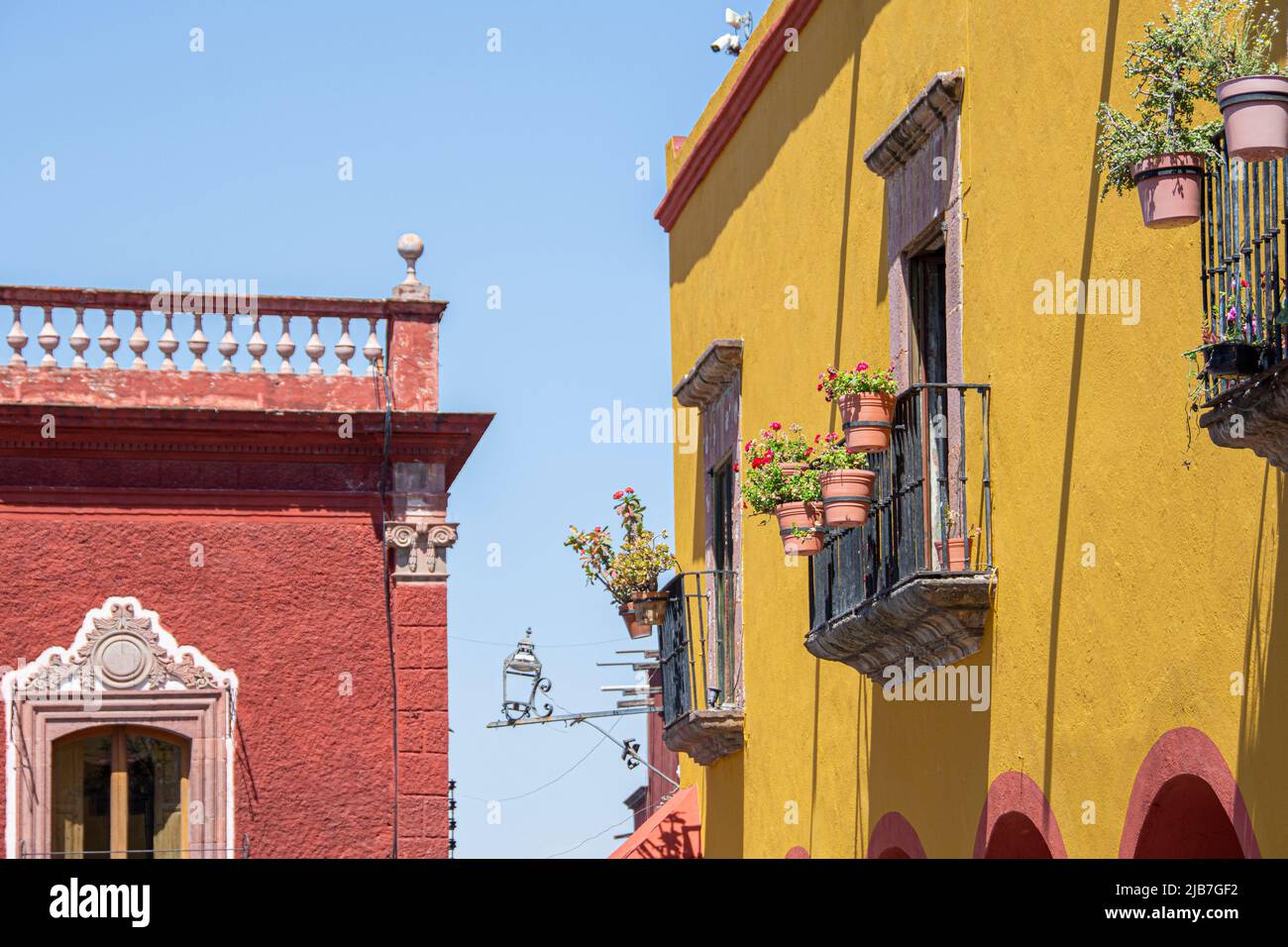 Due edifici kitty angolo l'uno dall'altro con un cielo blu pallido sullo sfondo. San Miguel de Allende, Messico Foto Stock