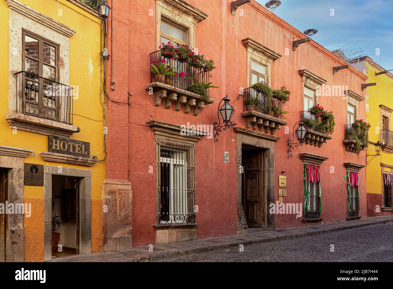 Una fila di case e appartamenti dipinti in tonalità di terra e colori. San Miguel de Allande. Foto Stock