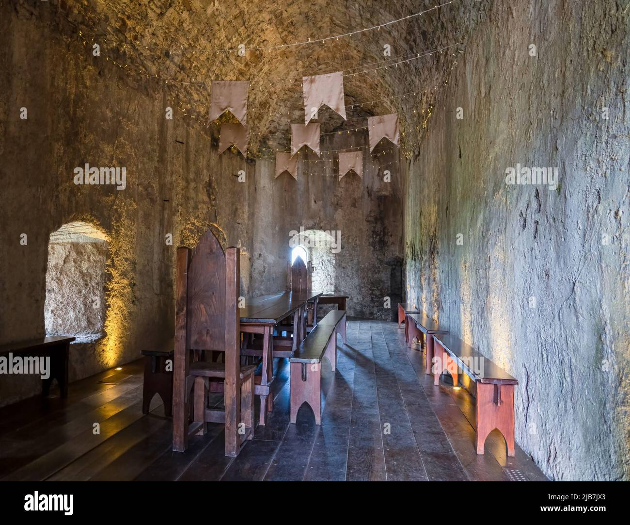 una sala da pranzo medievale con tavolo e sedie d'epoca Foto Stock