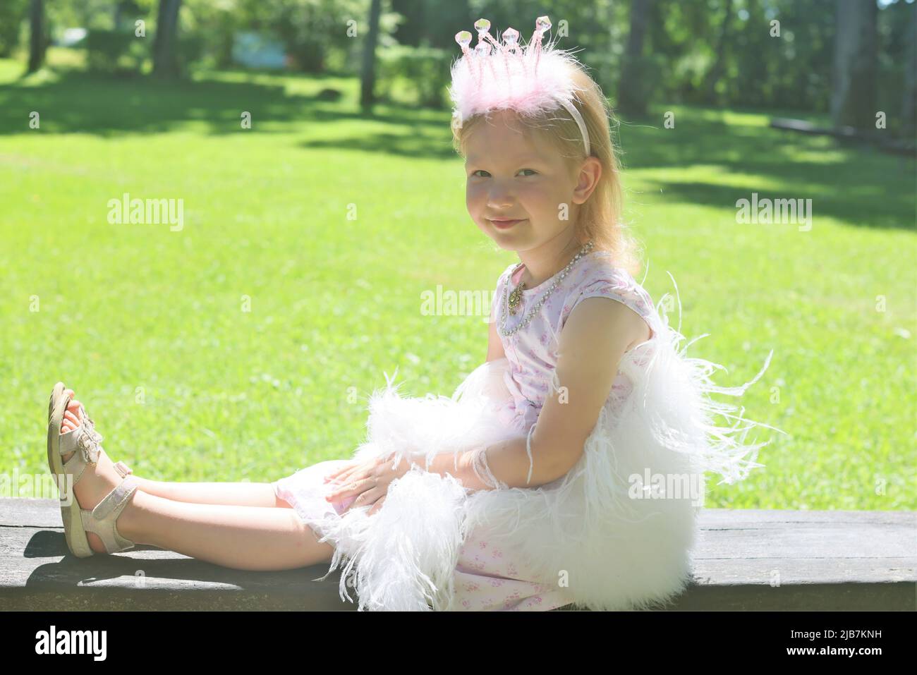 Campagna della Lettonia Giugno 17 2021, bambina di 4 anni che si posa come una principessa vestita di caldo sorriso rosa Foto Stock