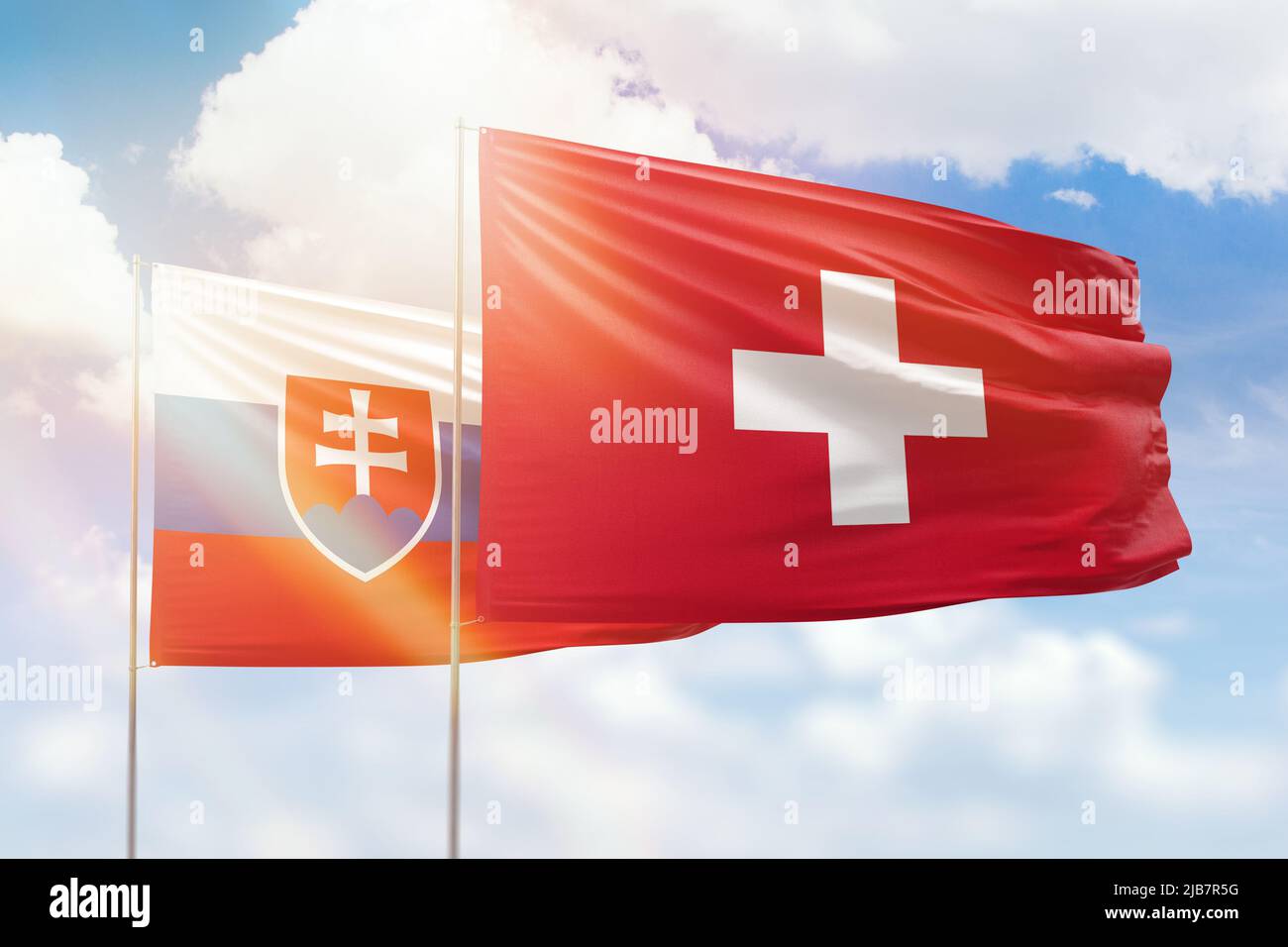 Cielo azzurro soleggiato e bandiere di svizzera e slovacchia Foto Stock