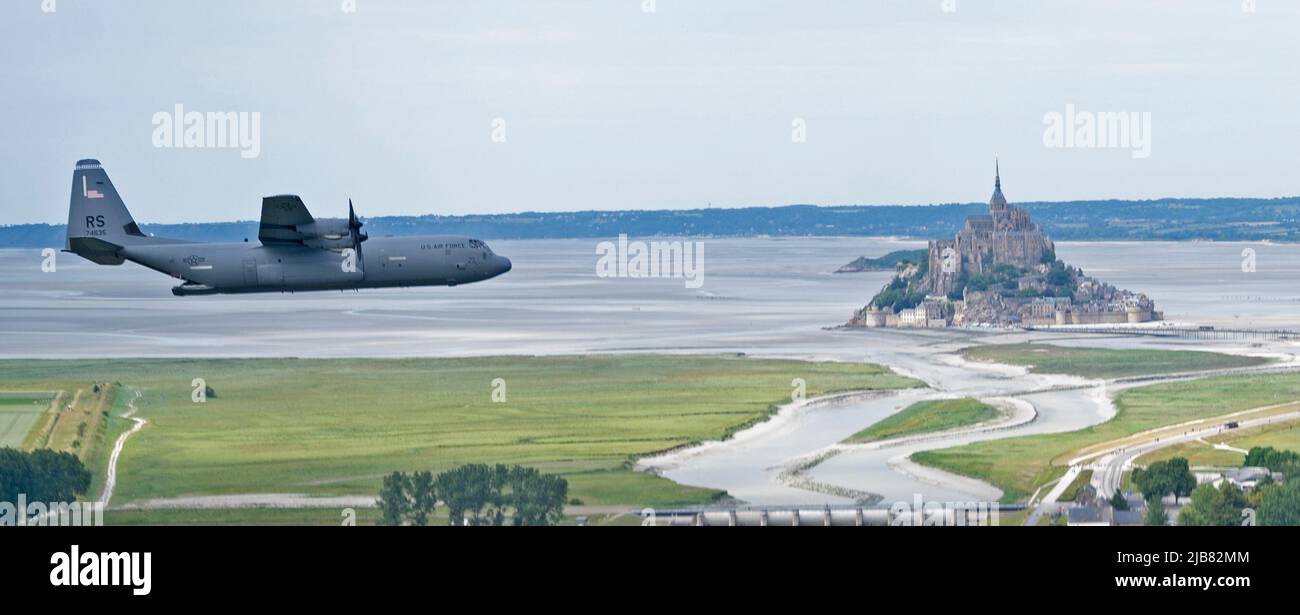 Un aereo C-130J Super Hercules assegnato al 37th Airlift Squadron dalla base aerea di Ramstein, Germania, vola oltre Mont Saint-Michel in Normandia, Francia, 2 giugno 2022. 37th COME ha un lignaggio che deriva da squadroni che hanno partecipato all'invasione della Francia, facendo cadere truppe e portando deltaplani sopra la Normandia, al fine di proteggere città e ponti prima che il resto delle forze alleate potrebbe tempesta le spiagge durante la seconda guerra mondiale. (STATI UNITI Air Force foto di Capt. Matt Bilbrey) Foto Stock