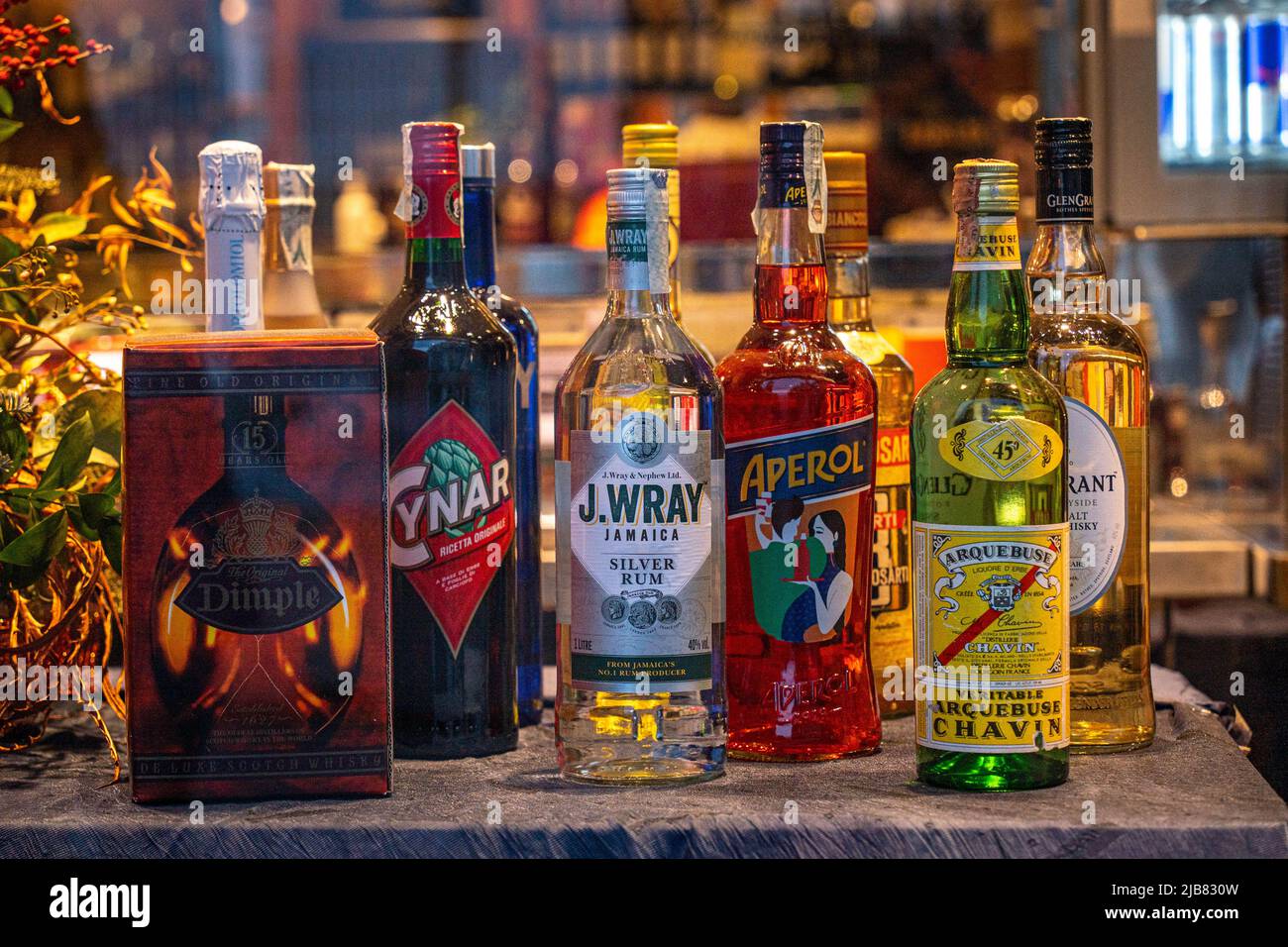Venezia, Italia - 18.02.2022: Bottiglie di liquori globali assortiti, tra cui whiskey, aperol, rum e chavin Arquebuse Foto Stock