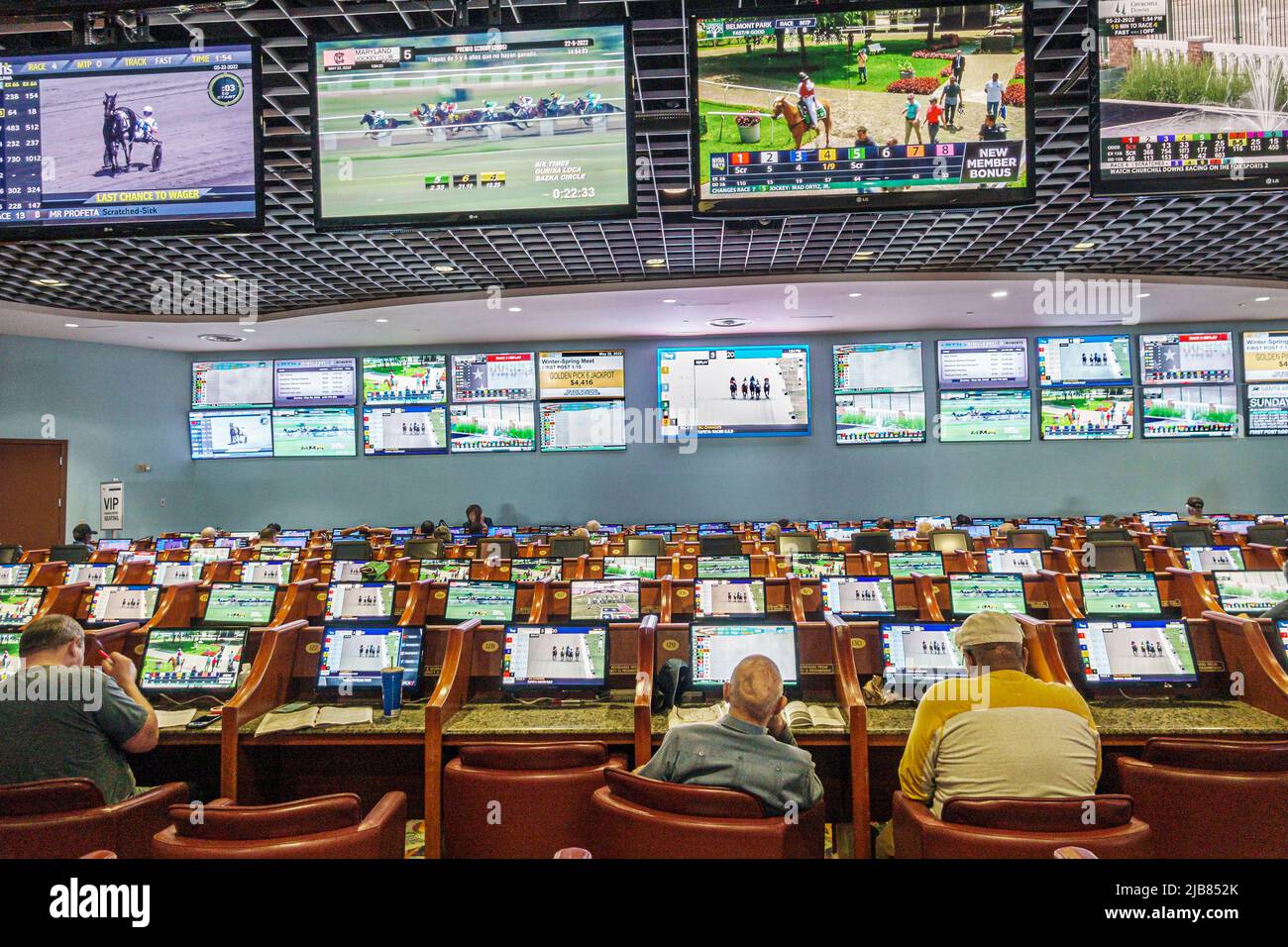 Hallandale Florida Miami, circuito di corse di cavalli purosangue del Gulfstream Park, all'interno schermi video interni betters giocatori uomini Foto Stock