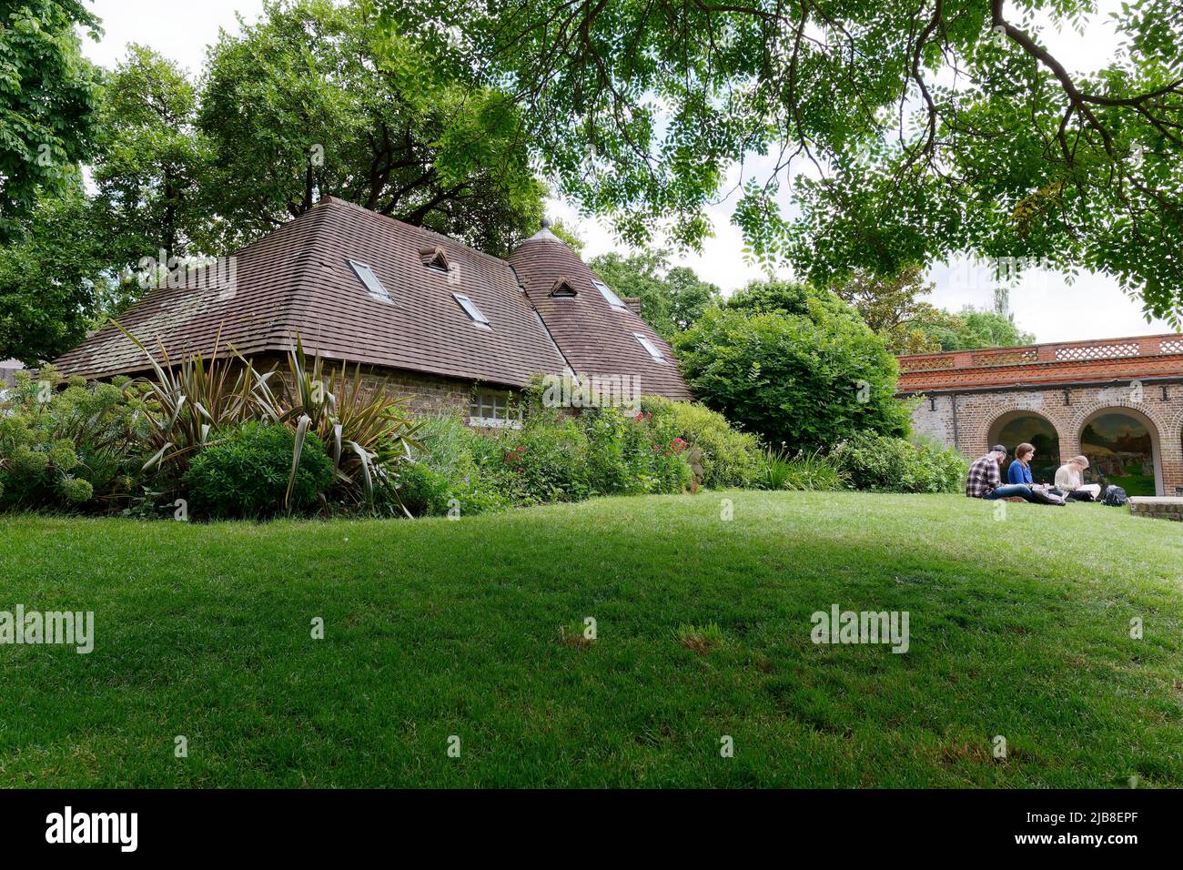 Londra, Grande Londra, Inghilterra, maggio 28 2022: Famiglia rilassante sul prato vicino al cottage a Holland Park nella zona di Kensington in primavera. Foto Stock