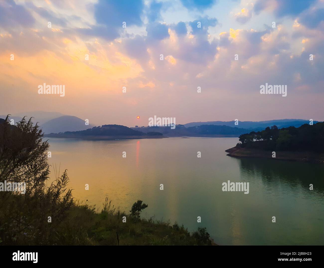 spettacolare cielo al tramonto di sera con riflessi del fiume da un angolo piatto Foto Stock