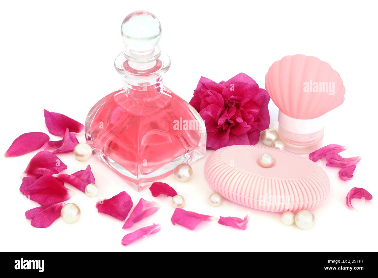 Profumo di rosa in bottiglia di vetro art deco con fiore, petali e perle con sapone e idratante per trattamenti di bellezza su sfondo bianco. Rosa rugosa. Foto Stock