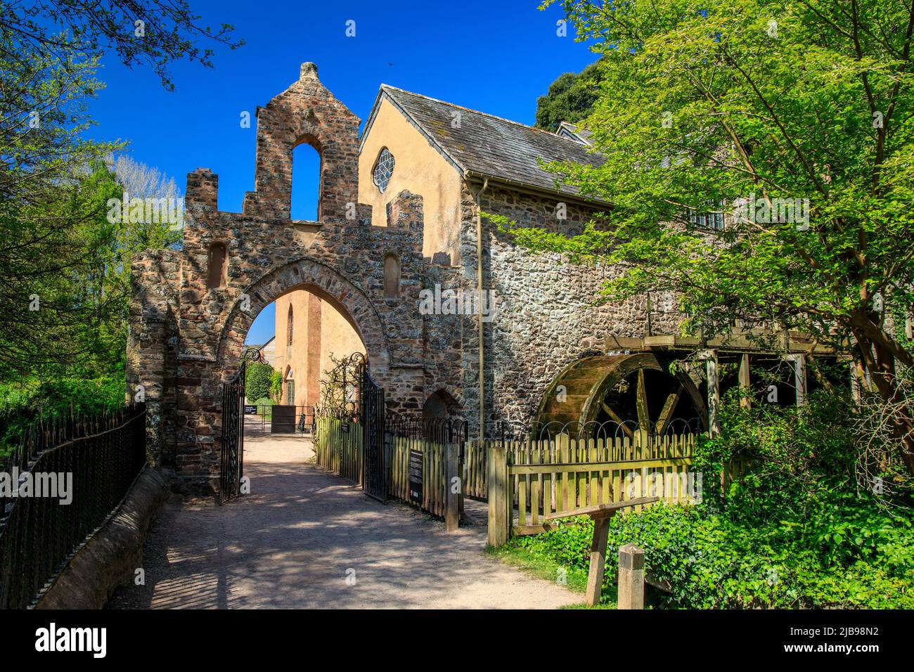 L'arco in pietra al mulino ad acqua restaurato con due ruote in legno a Dunster Castle, Somerset, Inghilterra, Regno Unito Foto Stock