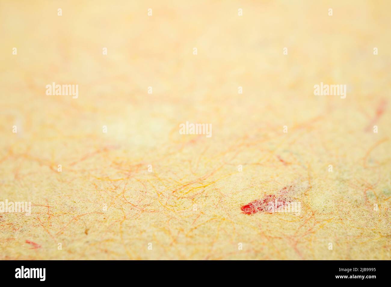 Primo piano estremo di carta gialla fatta a mano con profondità di campo poco profonda. Foto Stock