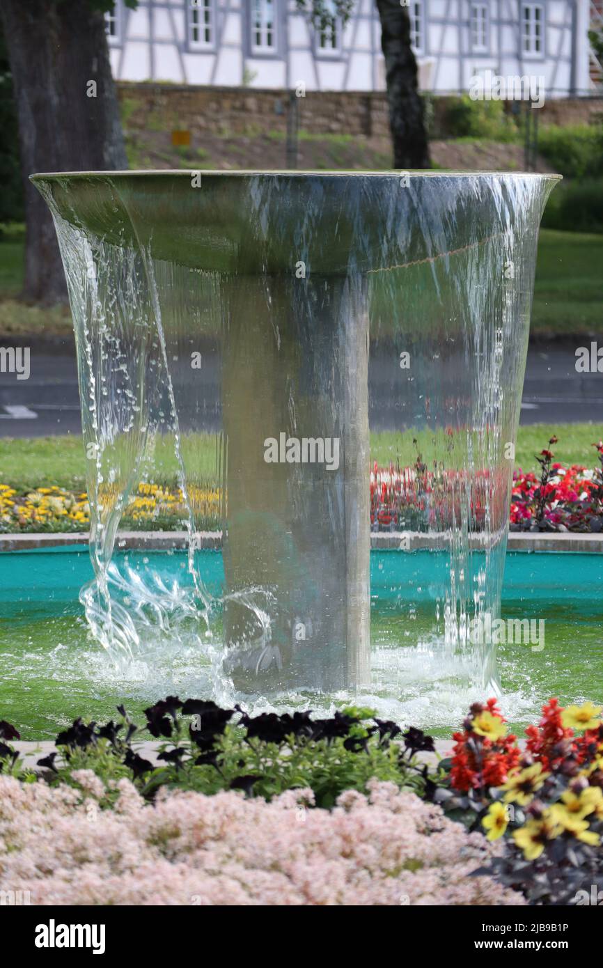 Una fontana overflow con piante di fiori tutto intorno Foto Stock