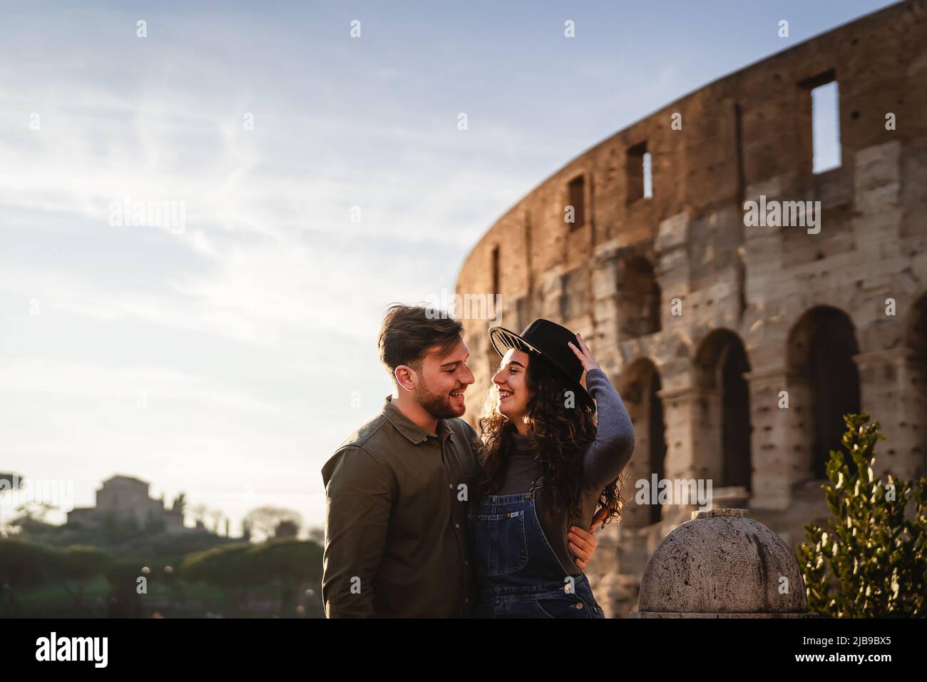 Giovane coppia romantica che ha tenero momento di fronte al Colosseo di Roma Foto Stock