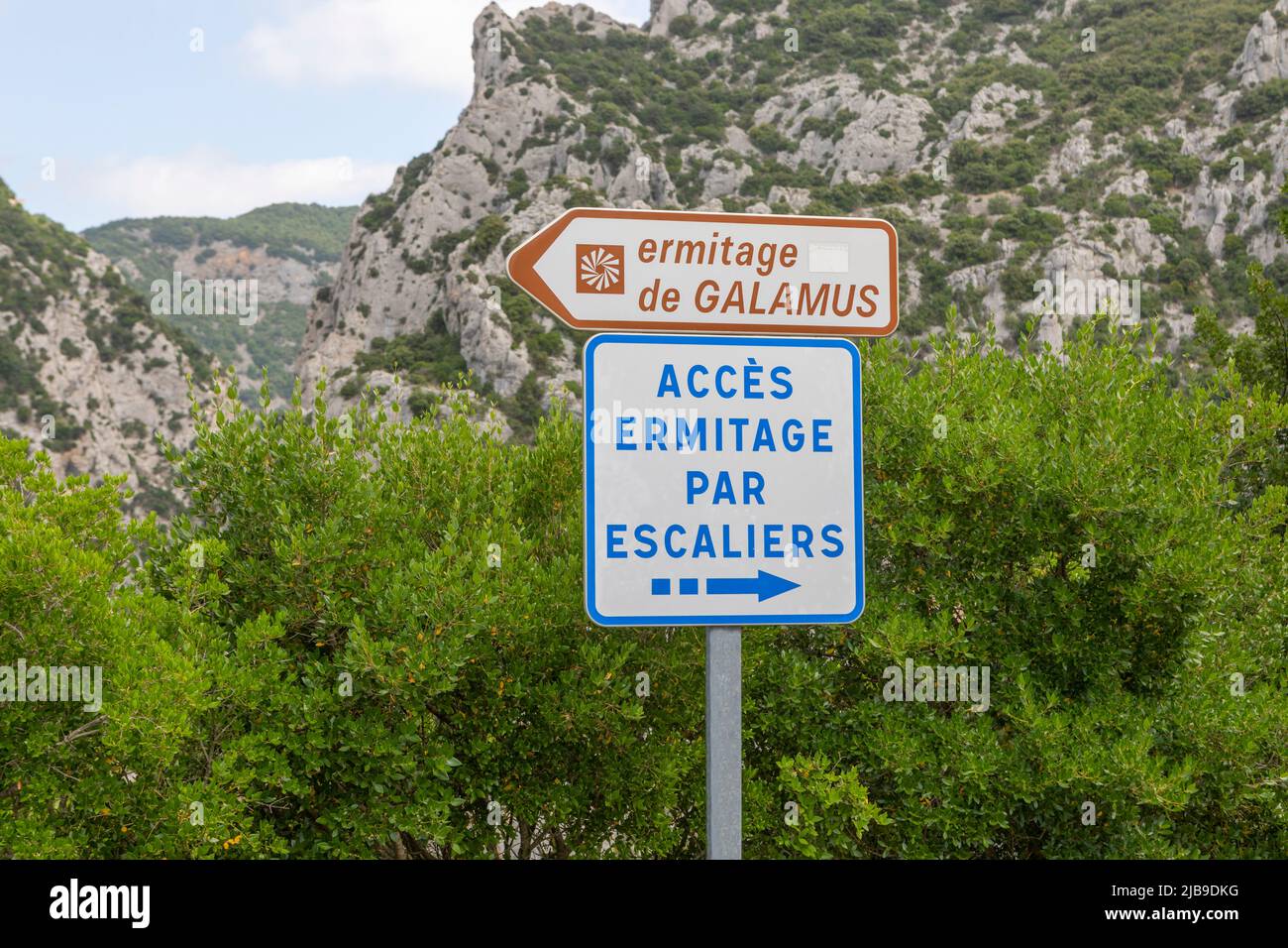 Un segno per l'eremo di Saint-Antoine de Galamus troglodita è stato tagliato fuori dalla roccia nel 7th secolo, sul lato della gola. Foto Stock