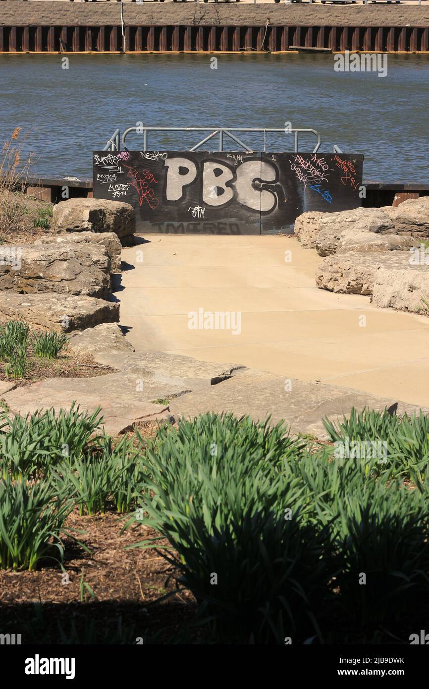 Le lettere PBC spruzzano dipinto su una parete di fronte al mare. Foto Stock