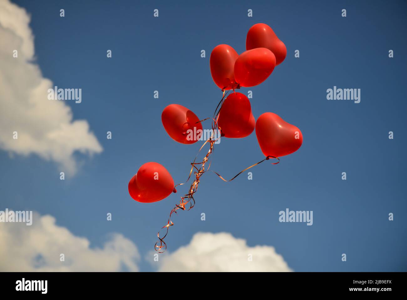 Cuore rosso palloncini sagomati fluttuante nel cielo. Il giorno di san valentino il simbolo Foto Stock