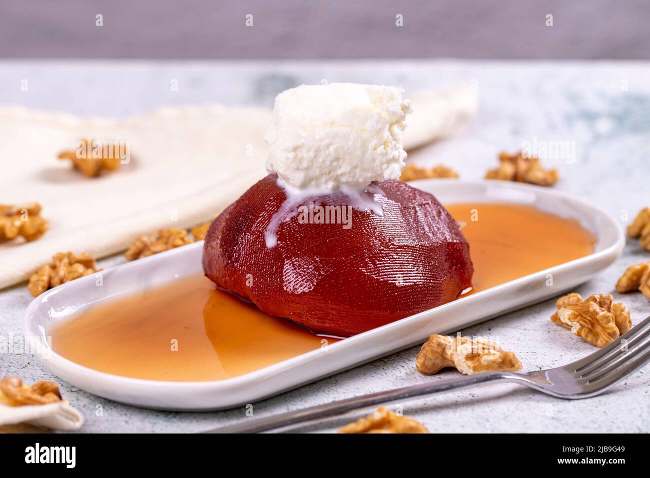 Dolce di mele cotogne. Prelibatezze della cucina tradizionale turca. Dolce di mele cotogne con panna su sfondo di pietra. Primo piano. Nome locale ayva tatlisi Foto Stock