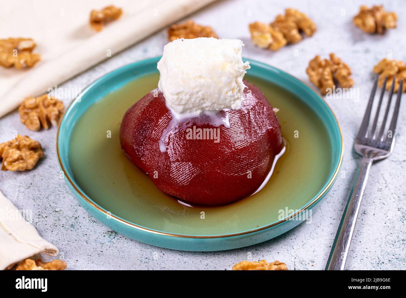 Dolce di mele cotogne. Prelibatezze della cucina tradizionale turca. Dolce di mele cotogne con panna su sfondo di pietra. Primo piano. Nome locale ayva tatlisi Foto Stock