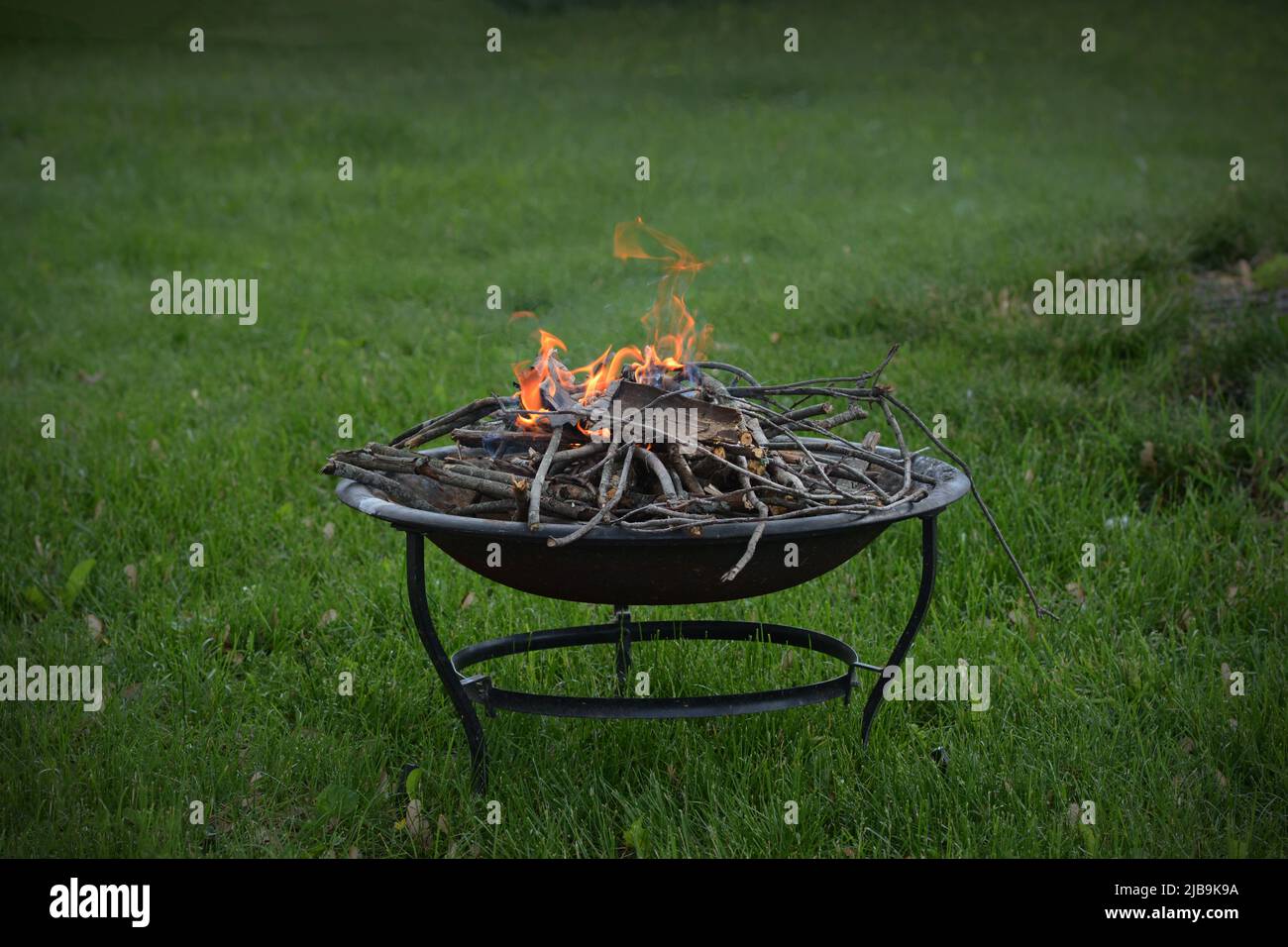 Un anello di fuoco, o buca di fuoco, brucia sicuro in un cortile dei proprietari di abitazione. Foto Stock
