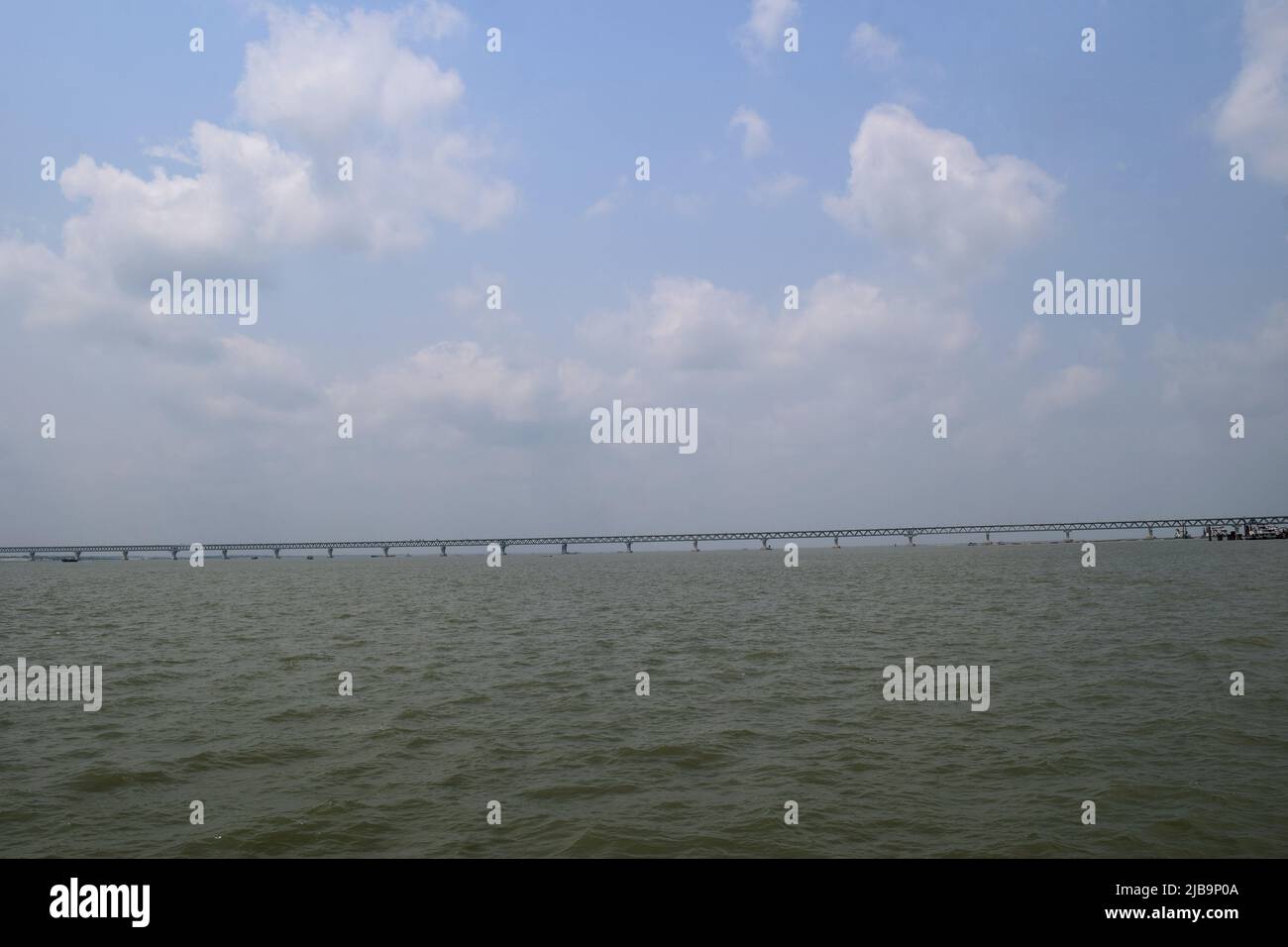 Munshiganj, Bangladesh - 06 aprile 2022: Fiume Padma e ponte multiuso Padma. Onde del fiume e cielo nuvoloso. Foto Stock