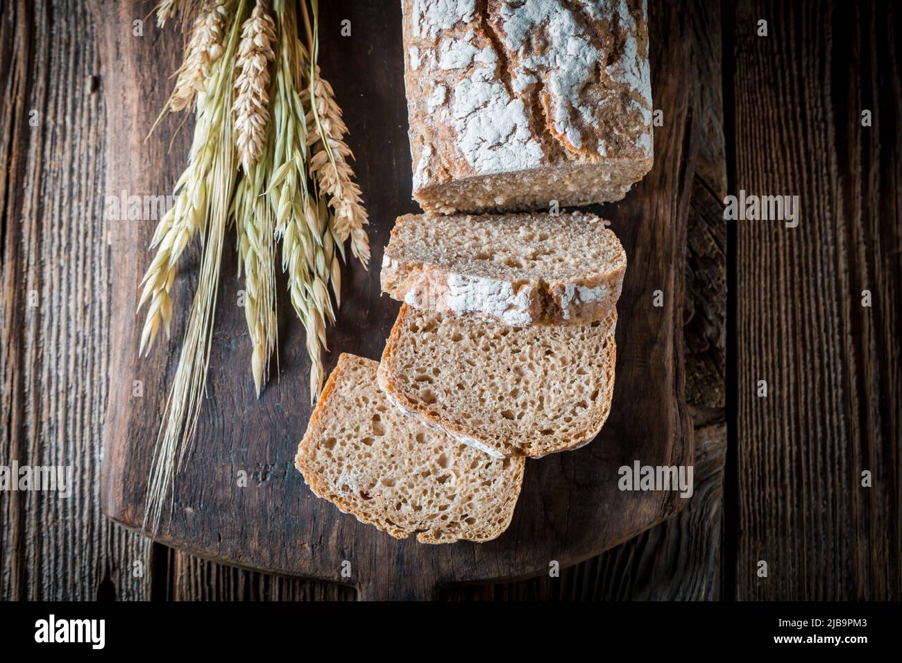 Pane delizioso e sano con grani interi su tavola di legno Foto Stock