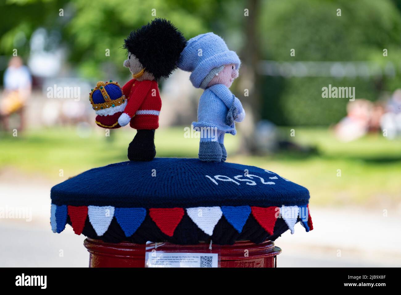 Ballater, Scozia, Regno Unito. 4 giugno 2022. La celebrazione del Giubileo del platino della Regina si celebra nel villaggio di Ballater, vicino a Balmoral, sul Royal Deeside, nell'Aberdeenshire. PIC; un “box topper” uncinetto Regina dispensando una regale garanzia su un pilastro di ufficio postale nel villaggio. Iain Masterton/Alamy Live News Foto Stock