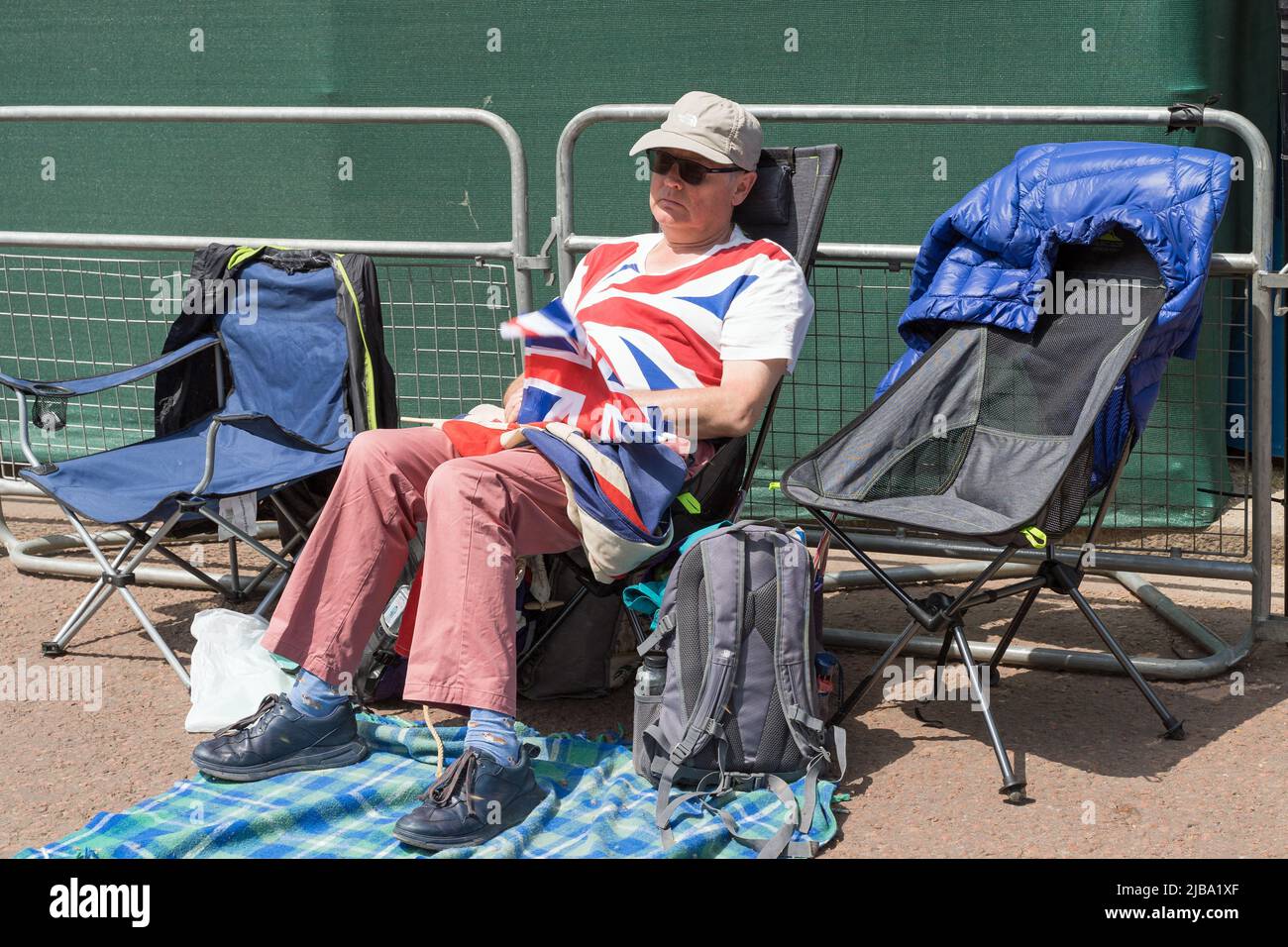 Uomo addormentato nella sua sedia a sdraio in attesa nel Mall per le celebrazioni del Giubileo del platino della Regina. Londra - 4th giugno 2022 Foto Stock
