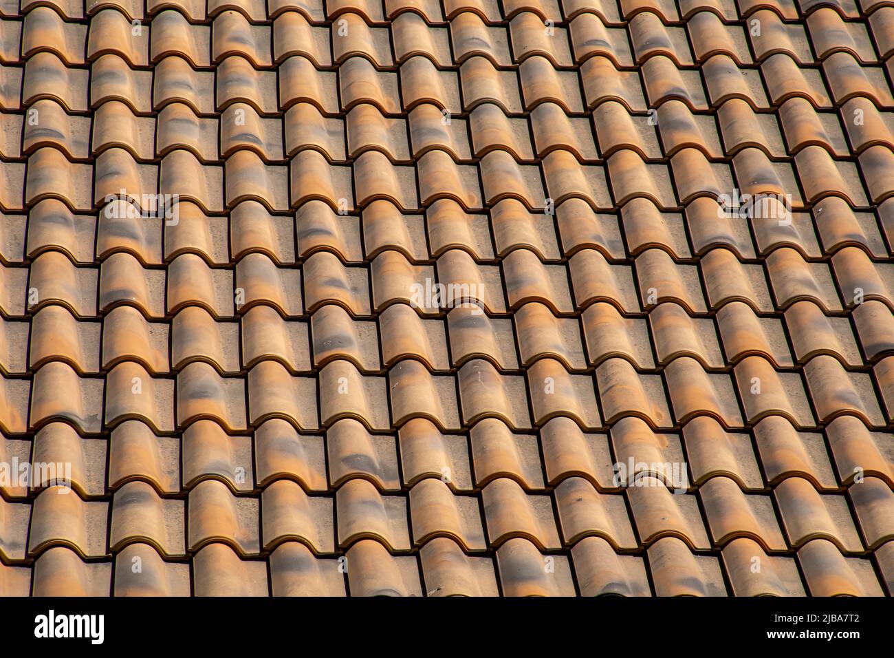 Tegole a mezza botte da un tetto resistente alle intemperie che creano una texture omogenea e geometrica Foto Stock Tegole a mezza botte da un tetto resistente alle intemperie che creano una texture omogenea e geometrica Foto Stock