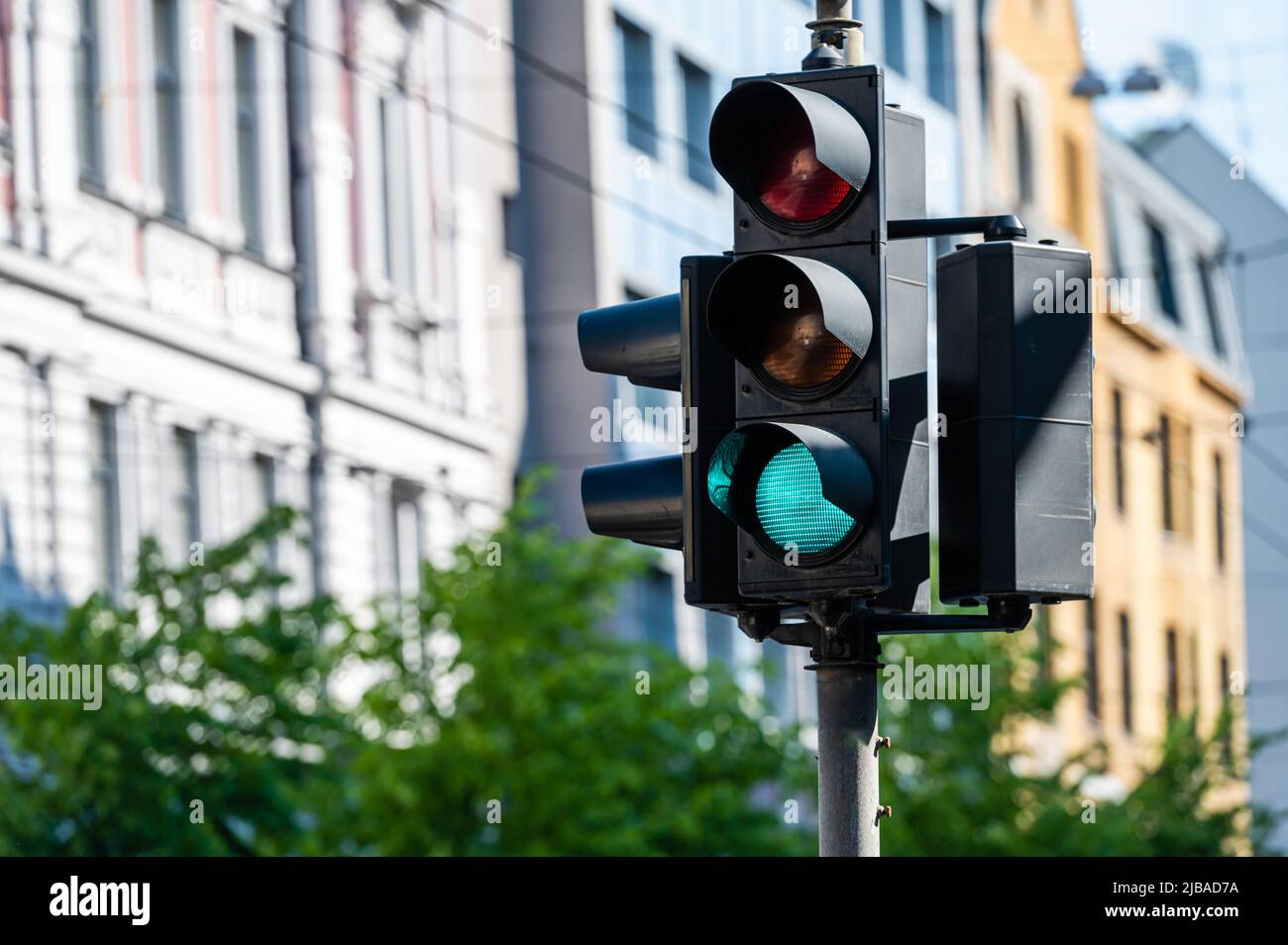 semaforo con semaforo verde sullo sfondo della strada urbana sfocata, primo piano Foto Stock
