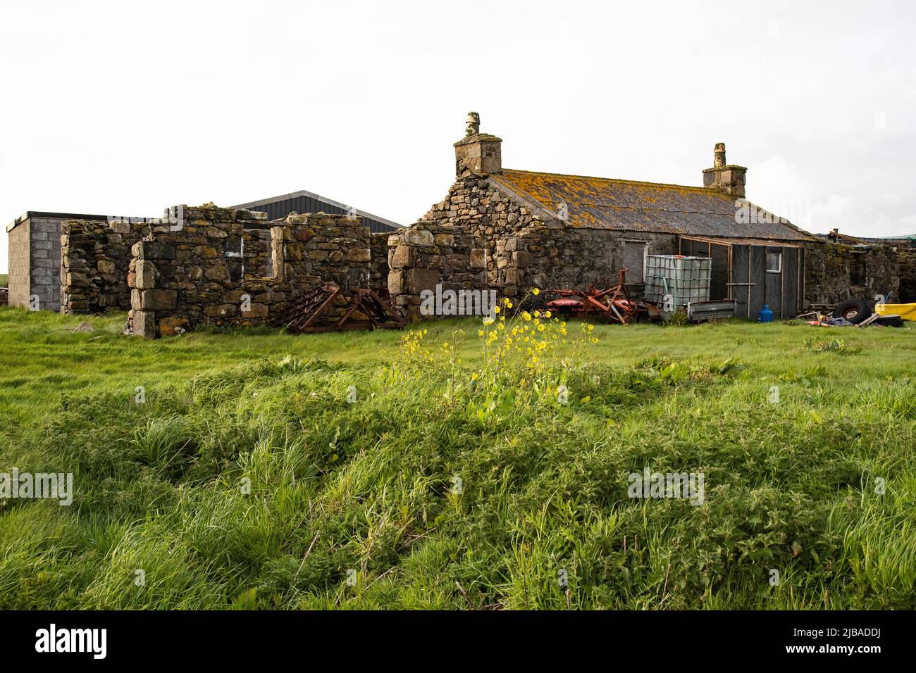Un gruppo di case in pietra derelitto crofters in tarda serata su terra paludosa in Nord Uist, Ebridi esterne, Scozia Foto Stock