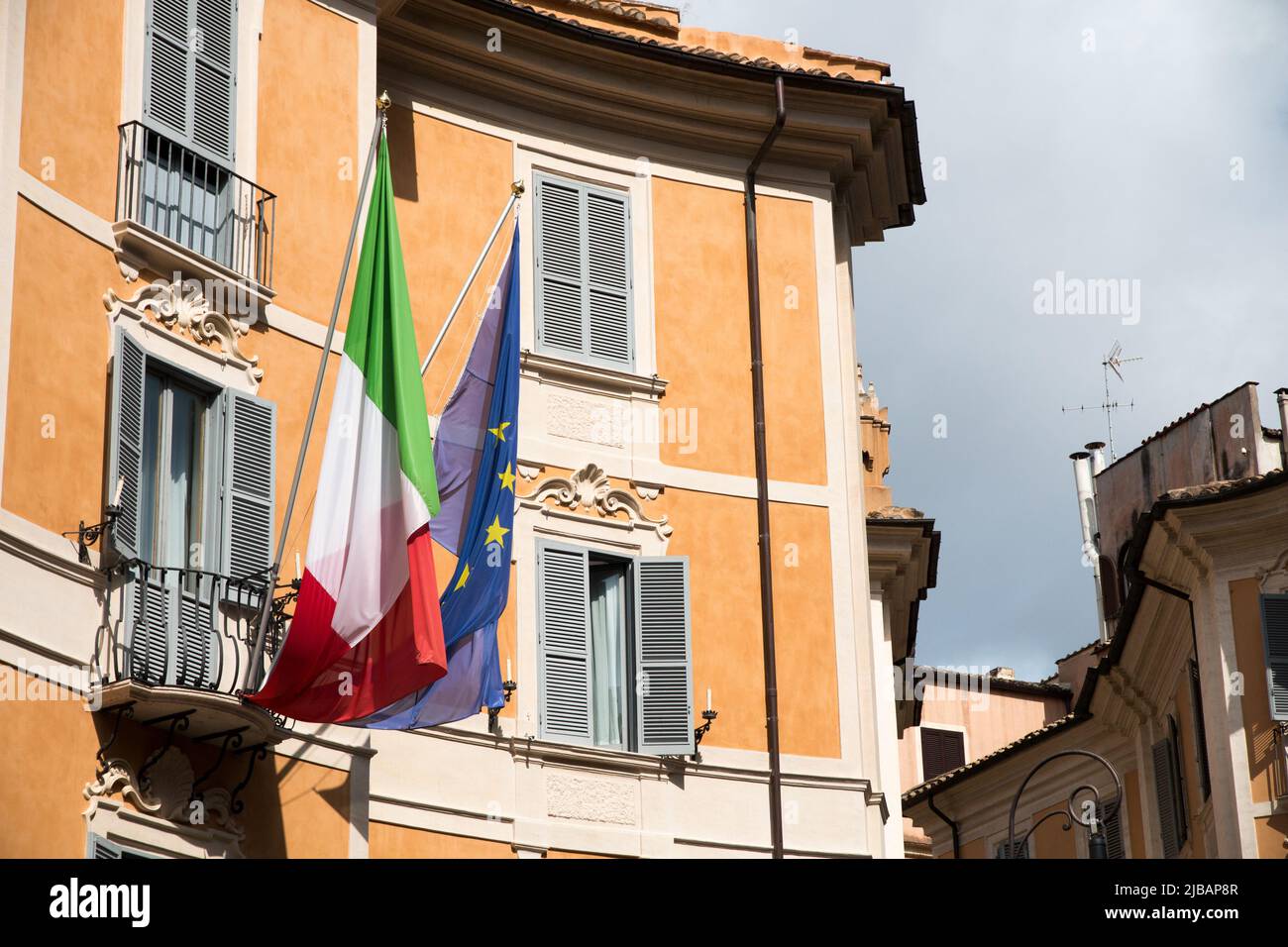 Bandiera europea e bandiera italiana appese su un balcone in Italia durante il giorno. Europa. Foto Stock