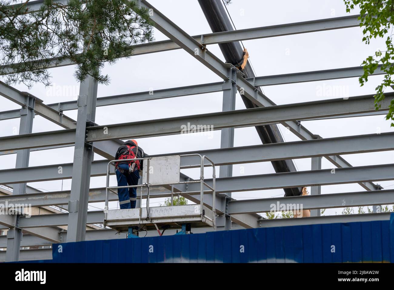 un operatore edile dotato di cintura di sicurezza per il lavoro in altezza Foto Stock