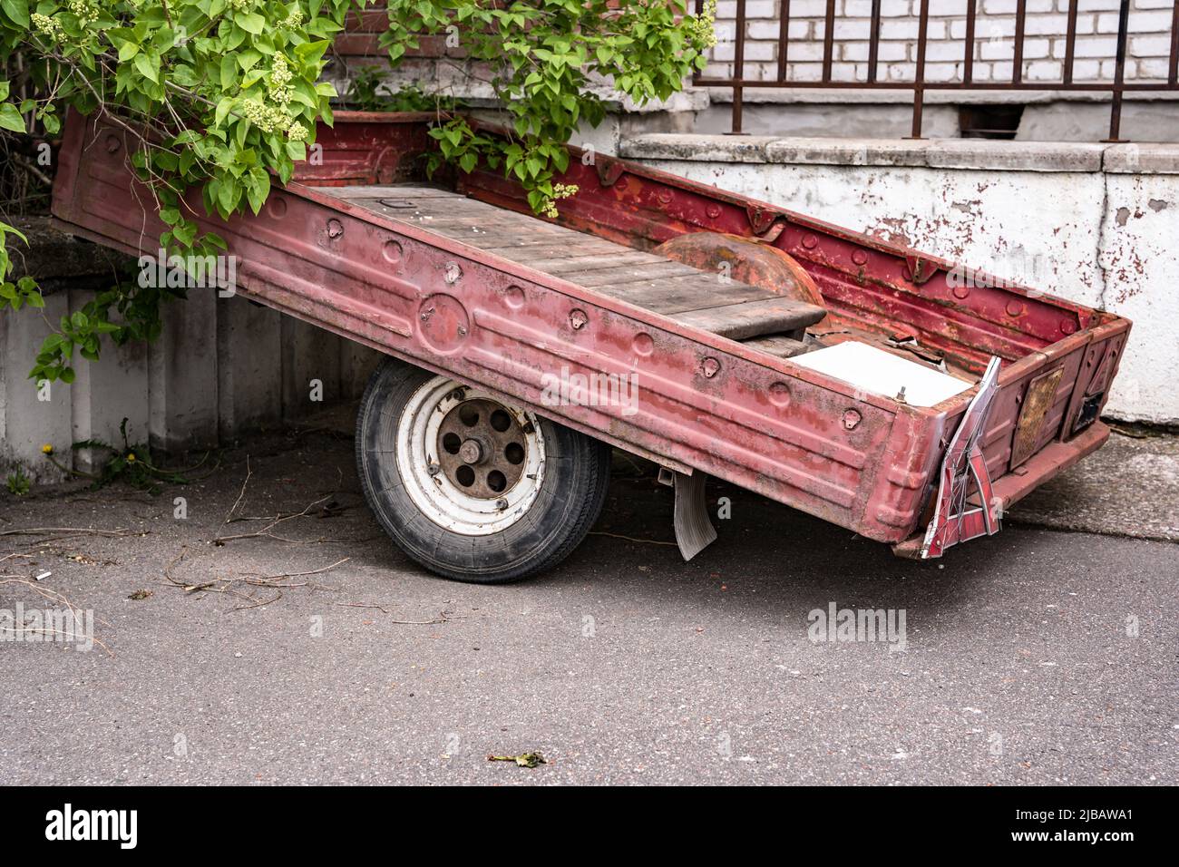 un vecchio rimorchio di carico dell'automobile per un'automobile del passeggero parcheggiata vicino alla casa Foto Stock