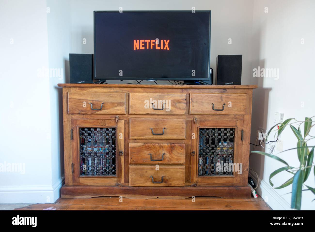Servizio di streaming Netflix sulla TV in cima a un tavolo antico Foto Stock
