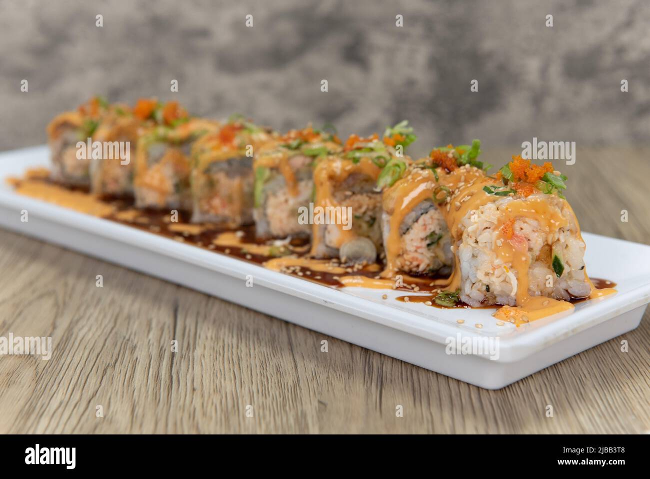 Cucina asiatica suhi roll con granchio piccante mescolato con carne krab e condito con avocado e salmone per un pasto molto abbondante. Foto Stock