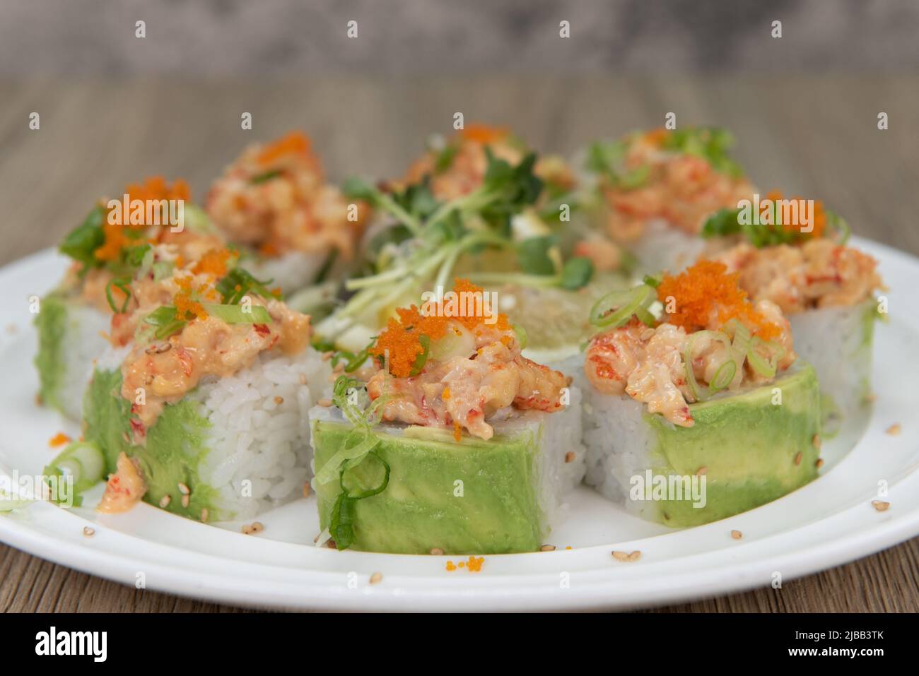 Cucina asiatica sushi roll con aragosta e tempura di gamberi con cipolla verde e masago per un pasto molto abbondante. Foto Stock