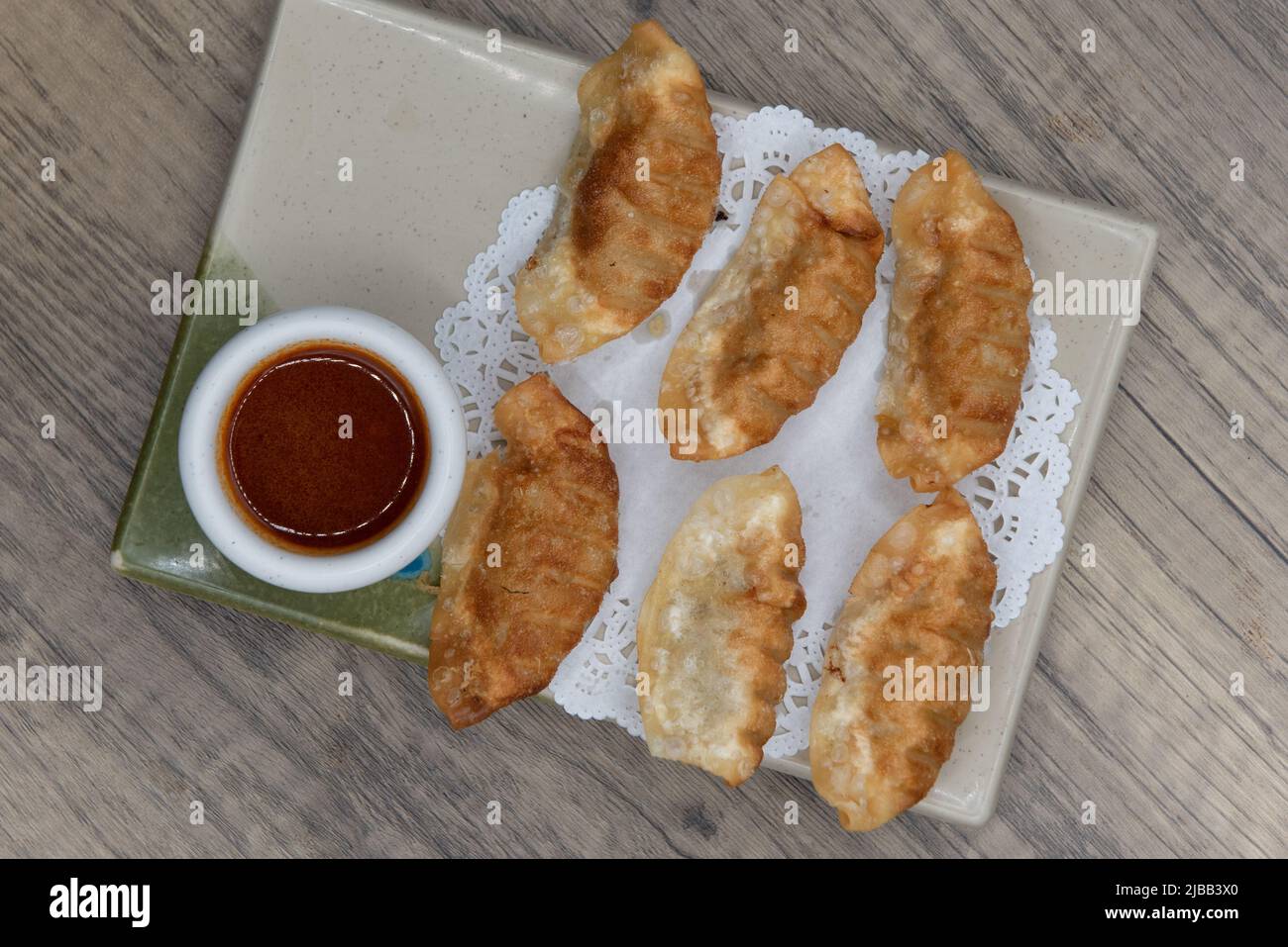 Vista dall'alto della cucina asiatica gyoza croccante fritta con salsa da immersione per un antipasto molto abbondante. Foto Stock