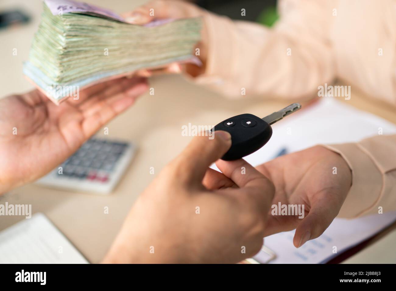 I commercianti di automobile o i responsabili di assicurazione hanno dato le chiavi ai clienti e ricevendo i soldi che hanno firmato l'acquisto o prestito Foto Stock