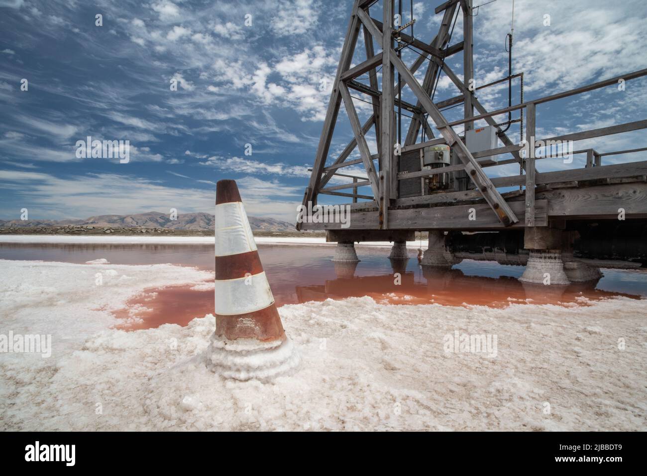 Un cono di traffico coperto e piattaforma in cristalli di sale al bordo di stagno di sale dove il sale marino è raccolto. Foto Stock