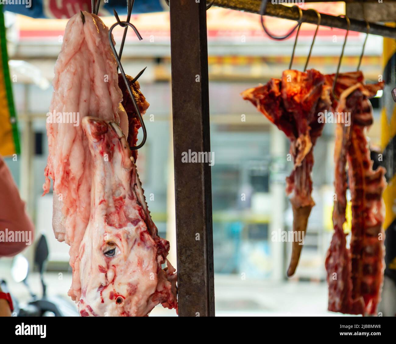 Carne fresca appesa al venditore di carne in un mercato taiwanese Foto Stock