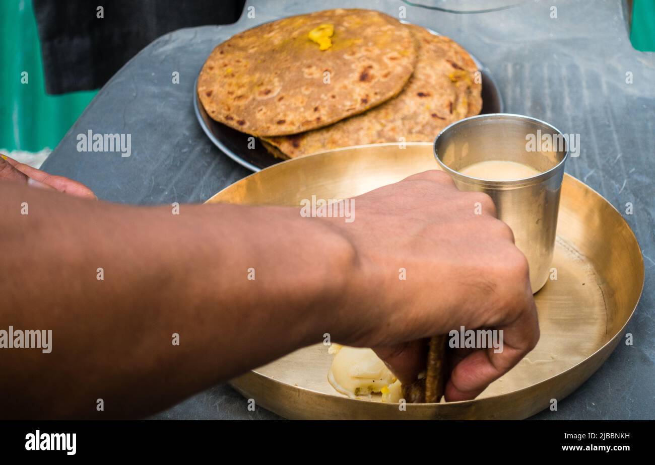 Colazione tradizionale dell'India del nord, pane rifatto o paratha con burro chiarificato servito su un piatto di ottone. uttarakhand, India Foto Stock