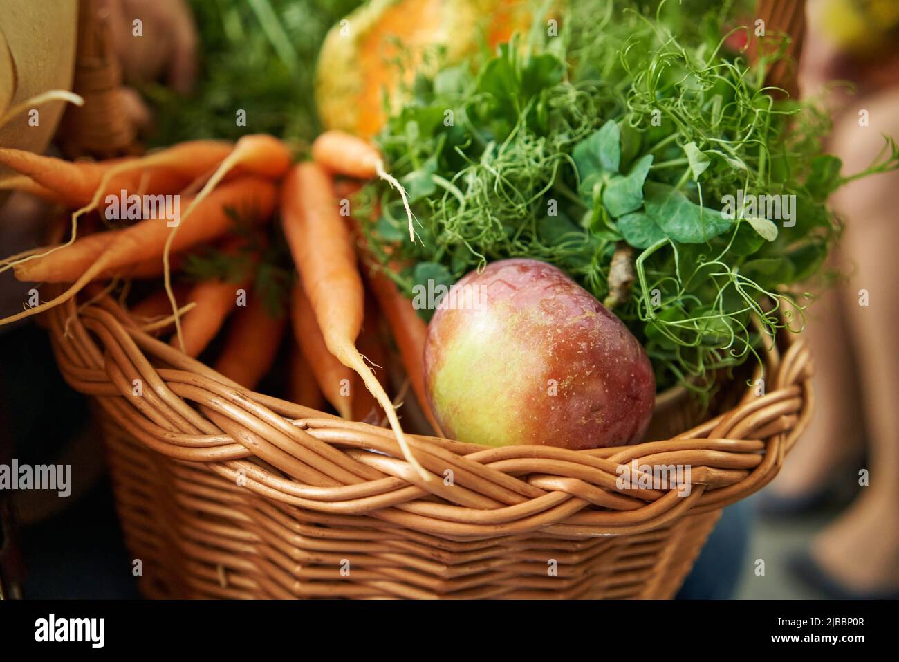 Cestino di vimini con frutta fresca, verdure e microgreens di piselli sulla via del ritorno dal mercato agricolo Foto Stock