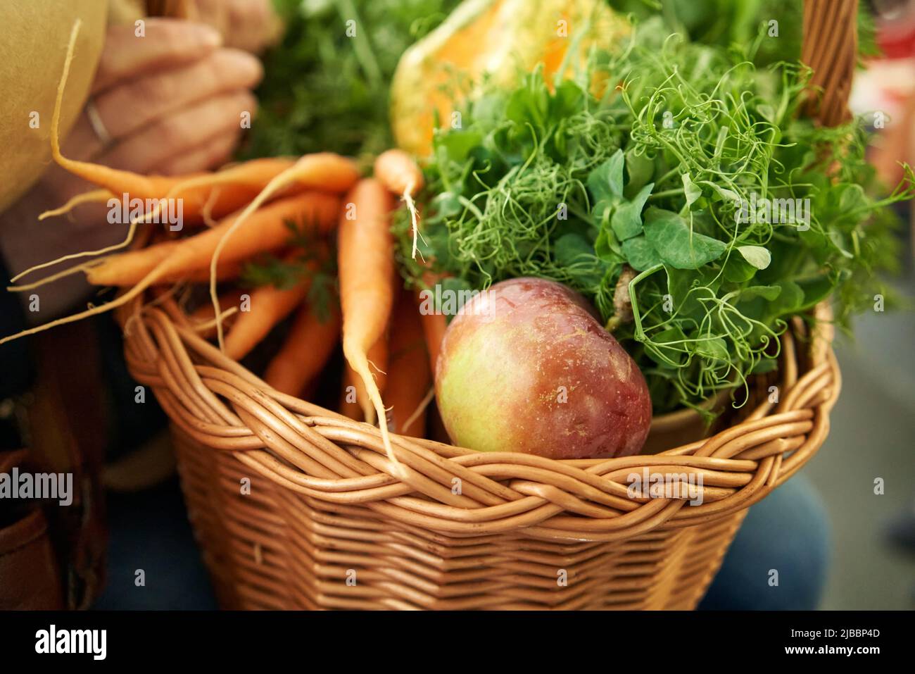 Mele, piselli freschi, microgreens e carote in un cestino sulla strada dal mercato agricolo Foto Stock